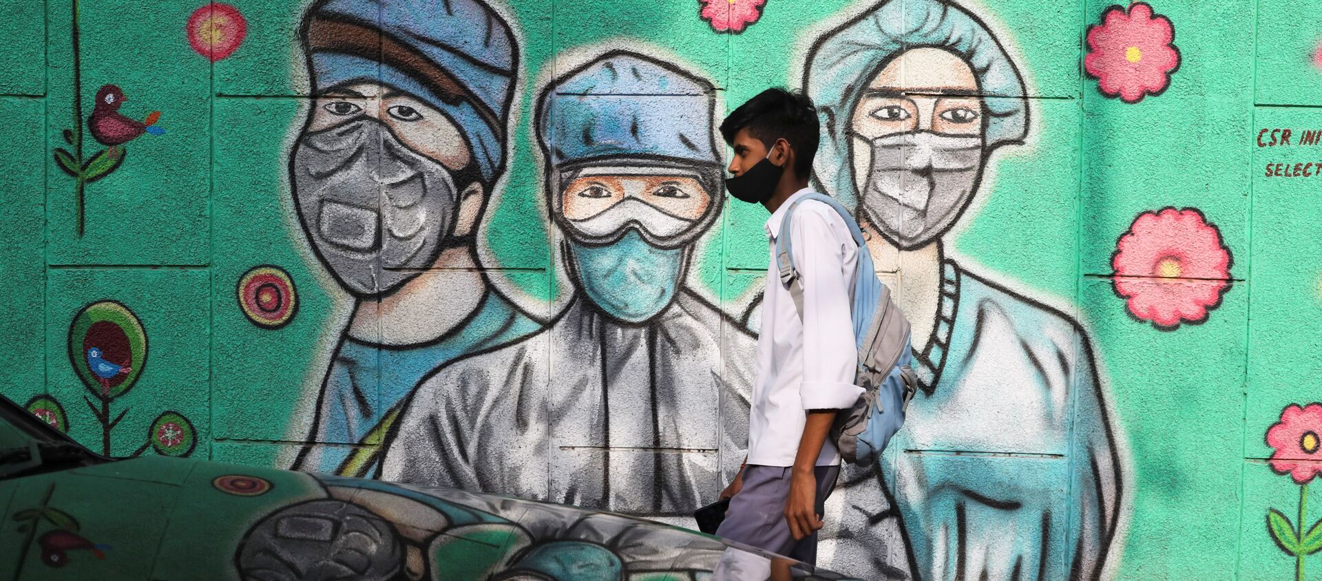 A boy walks past a graffiti amidst the spread of the coronavirus disease (COVID-19) on a street in New Delhi, India, March 22, 2021 - Sputnik International, 1920, 06.06.2021