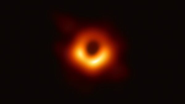 Using the Event Horizon Telescope, scientists obtained an image of the black hole at the center of galaxy M87, outlined by emission from hot gas swirling around it under the influence of strong gravity near its event horizon. - Sputnik International