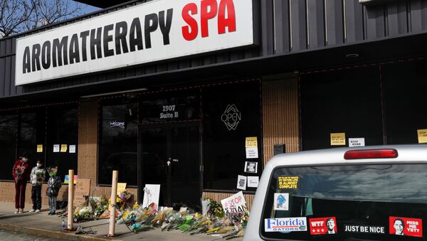 Children holding flowers stand during a vigil at a makeshift memorial outside the Aromatherapy Spa following the deadly shootings in Atlanta, Georgia, U.S. March 21, 2021 - Sputnik International
