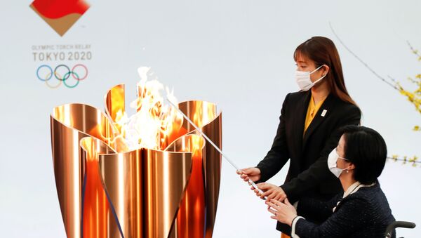 Actor Satomi Hishihara and Paralympian Aki Taguchi light the celebration cauldron on the first day of the Tokyo 2020 Olympic torch relay in Naraha, Fukushima prefecture, Japan March 25, 2021 - Sputnik International