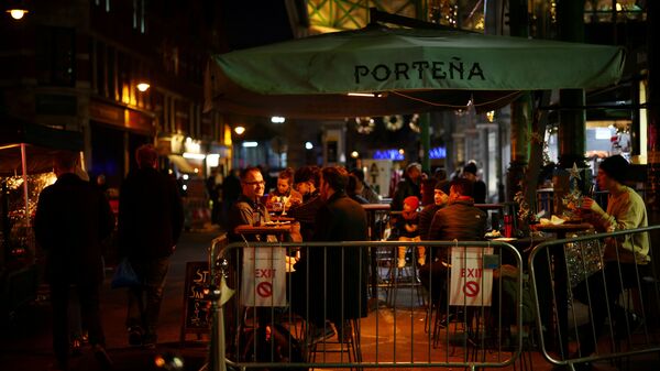 FILE PHOTO: People drink outside a bar as the spread of the coronavirus disease (COVID-19) continues, in London, Britain, December 15, 2020 - Sputnik International
