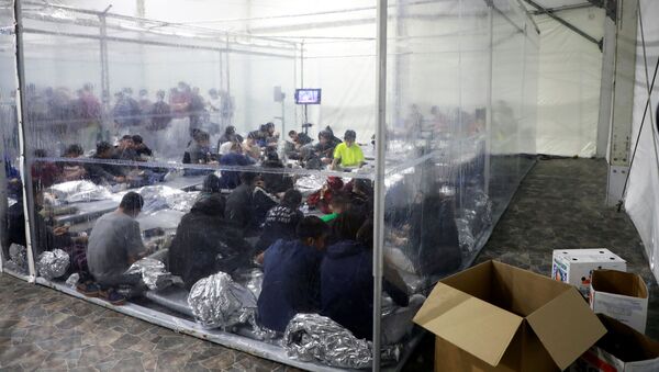 Migrants sit inside a temporary processing facility for migrants, including unaccompanied minors, in Donna, Texas, U.S. March 17, 2021 - Sputnik International