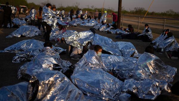 Linda, an asylum-seeking migrant from Honduras, awakes at sunrise next to others who took refuge near a baseball field after crossing the Rio Grande river into the United States from Mexico on rafts, in La Joya, Texas, U.S., March 19, 2021 - Sputnik International