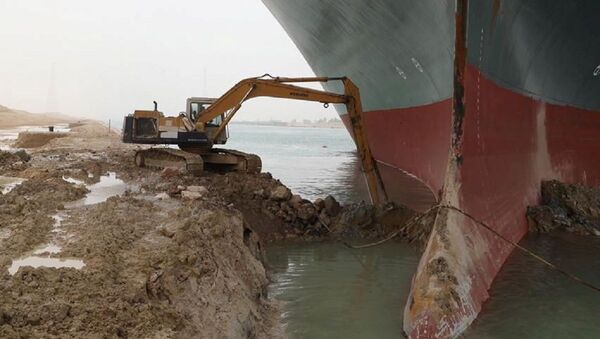 An excavator attempts to free stranded container ship Ever Given, one of the world's largest container ships, after it ran aground, in the Suez Canal, Egypt 25 March 2021. - Sputnik International