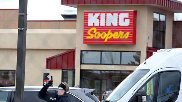 An FBI agent surveys the site of a mass shooting at a King Soopers grocery store in Boulder, Colorado, U.S. March 23, 2021. - Sputnik International