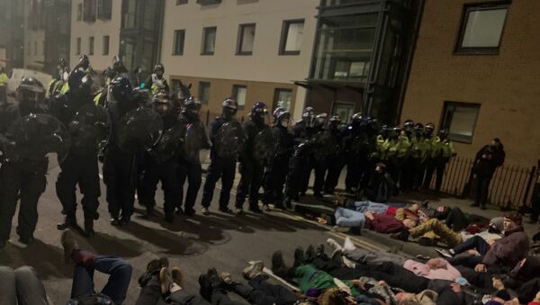 Police officers stand in position as protesters demonstrate against new policing laws in Bristol, Britain, early March 24, 2021, in this picture obtained from social media. - Sputnik International