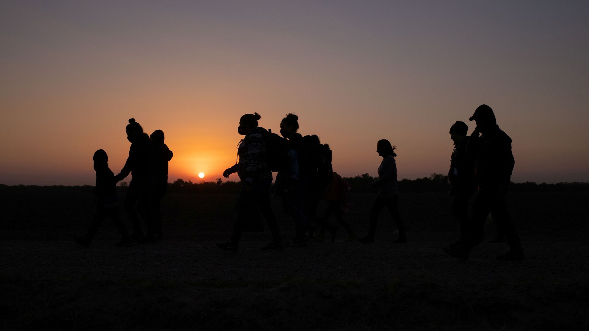 The sun rises as asylum-seeking migrants' families from Honduras and El Salvador walk towards the border wall after crossing the Rio Grande river into the United States from Mexico on a raft, in Penitas, Texas, U.S., March 26, 2021 - Sputnik International, 1920, 07.06.2021