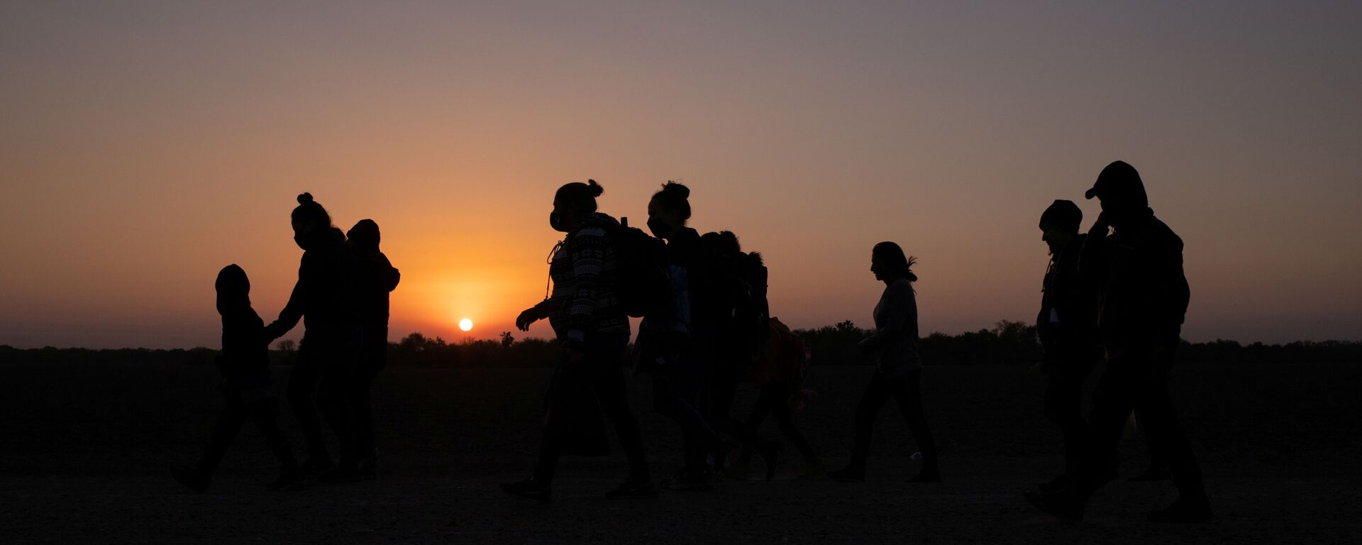 The sun rises as asylum-seeking migrants' families from Honduras and El Salvador walk towards the border wall after crossing the Rio Grande river into the United States from Mexico on a raft, in Penitas, Texas, U.S., March 26, 2021 - Sputnik International, 1920, 03.04.2022