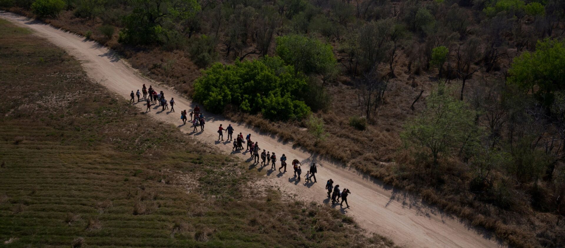 Asylum seeking migrant families from Central America walk towards the border wall after crossing the Rio Grande river into the United States from Mexico on rafts in Penitas, Texas, U.S., March 26, 2021 - Sputnik International, 1920, 09.04.2021