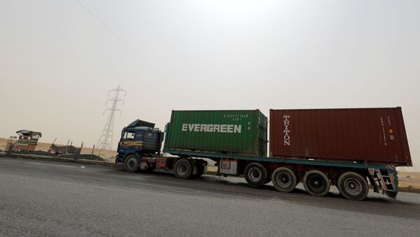 A truck carrying Evergreen and Triton containers waits to pass through the main gate of the El Ain El Sokhna port to the Suez Canal in dusty weather, 24 March 2021 - Sputnik International