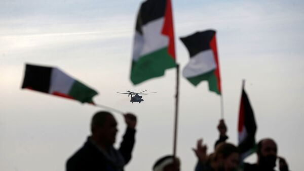 Demonstrators hold Palestinian flags as an aircraft carrying Israeli Prime Minister Benjamin approaches to land near the heritage site of ancient Susya, during a protest against Netanyahu's visit to the site, in Susya village in the Israeli-occupied West Bank March 14, 2021.  - Sputnik International
