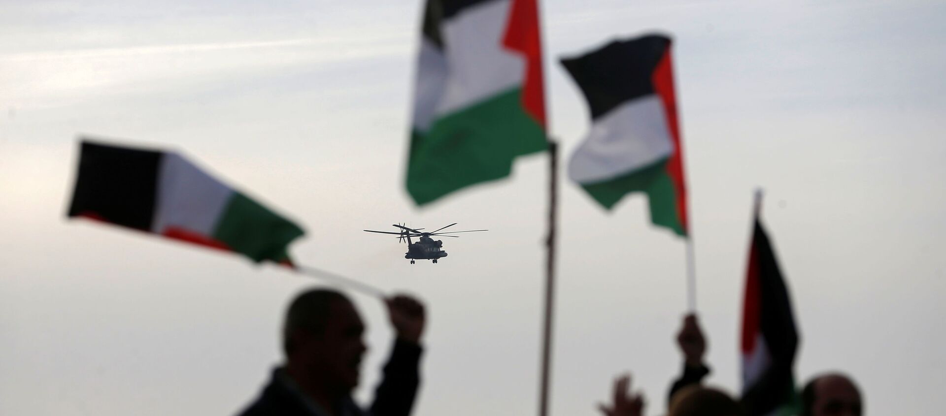 Demonstrators hold Palestinian flags as an aircraft carrying Israeli Prime Minister Benjamin approaches to land near the heritage site of ancient Susya, during a protest against Netanyahu's visit to the site, in Susya village in the Israeli-occupied West Bank March 14, 2021.  - Sputnik International, 1920, 21.05.2021