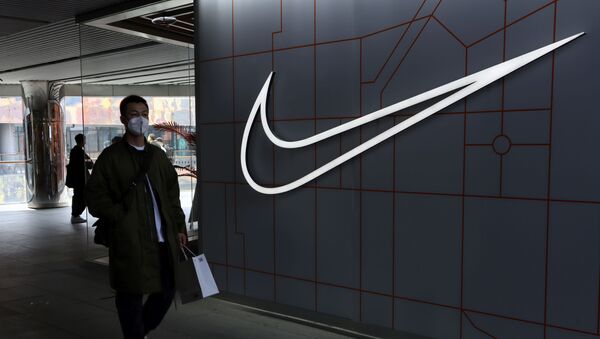 A man walks past a store of the sporting goods retailer Nike Inc at a shopping complex in Beijing, China March 25, 2021 - Sputnik International