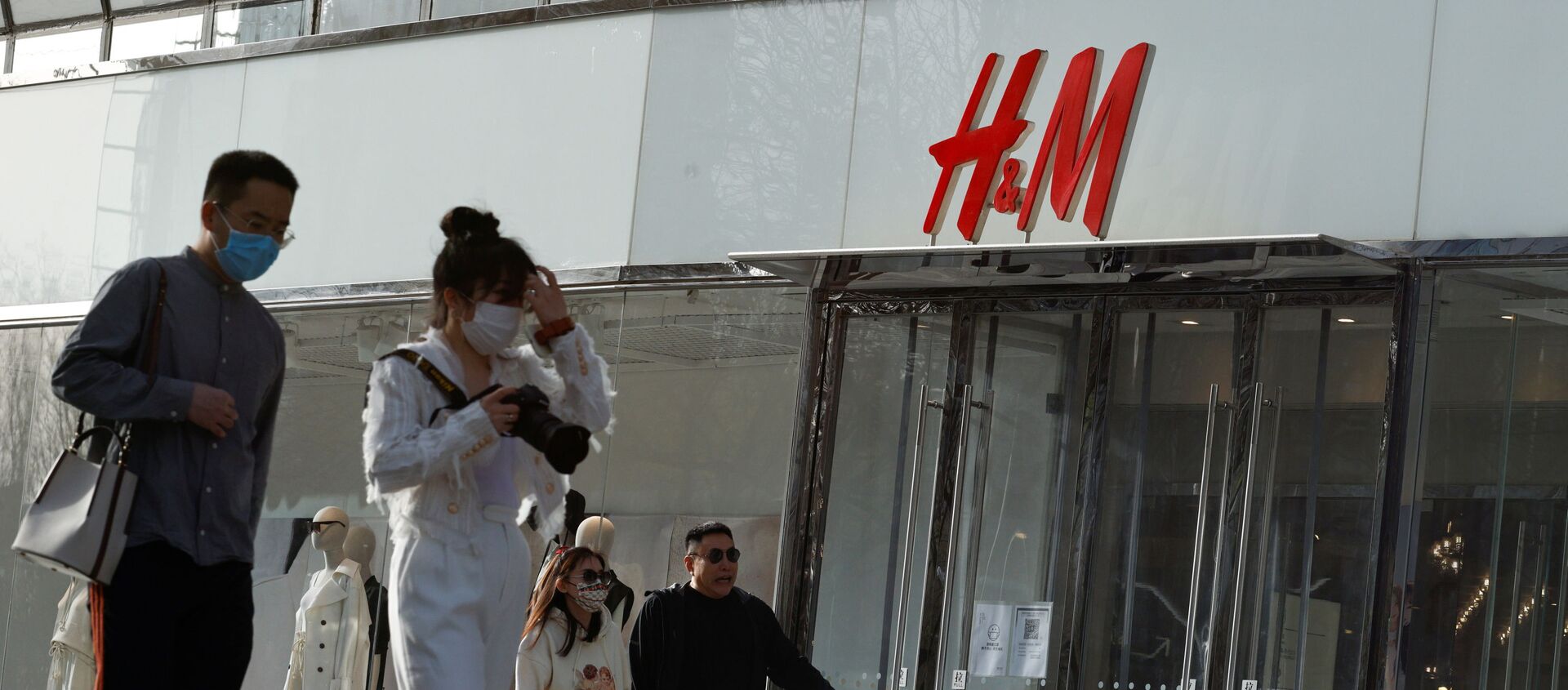People walk past an H&M store in a shopping area in Beijing, China, 28 March 2021 - Sputnik International, 1920, 29.03.2021