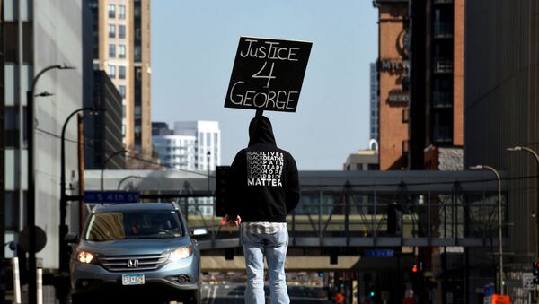 A demonstrator blocks traffic outside the Hennepin County Government Center during the first day of the trial of former police Derek Chauvin, who is facing murder charges in the death of George Floyd, in Minneapolis, Minnesota, U.S., March 29, 2021. - Sputnik International