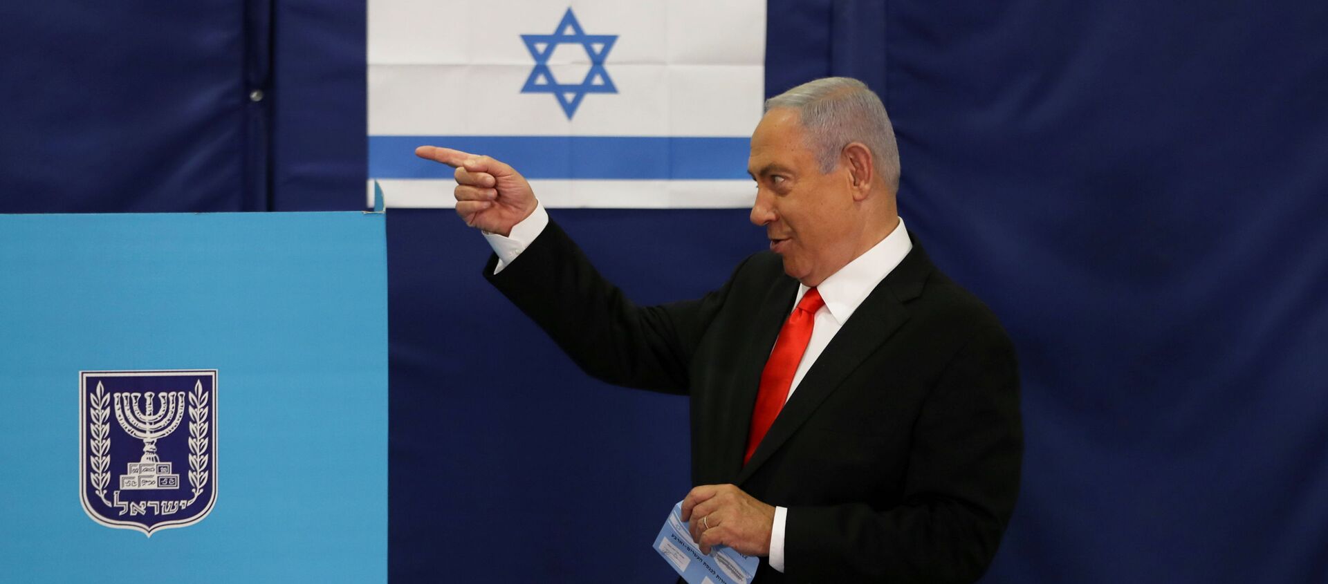 FILE PHOTO: Israeli Prime Minister Benjamin Netanyahu gestures while standing near a voting booth as he prepares to cast his ballot in Israel's general election, at a polling station in Jerusalem, 23 March 2021.  - Sputnik International, 1920, 30.03.2021