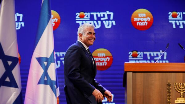 Yesh Atid party leader Yair Lapid walks towards the podium before delivering a speech following the announcement of exit polls in Israel's general election at his party headquarters in Tel Aviv, Israel March 24, 2021.  - Sputnik International