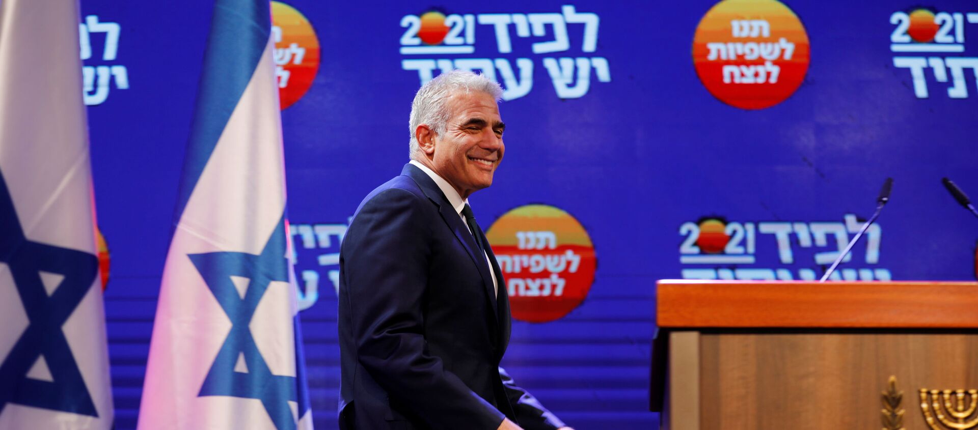 Yesh Atid party leader Yair Lapid walks towards the podium before delivering a speech following the announcement of exit polls in Israel's general election at his party headquarters in Tel Aviv, Israel March 24, 2021.  - Sputnik International, 1920
