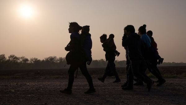 FILE PHOTO: Asylum-seeking mothers from Guatemala and Honduras carry their children after they crossed the Rio Grande river into the United States from Mexico on a raft, in Penitas, Texas, U.S., March 17, 2021. - Sputnik International