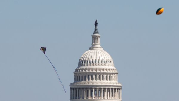 Kites and a football flies in the air near the U.S. Capitol as visitors gather to observe the annual cherry blossoms along the National Mall in Washington, U.S., March 29, 2021 - Sputnik International