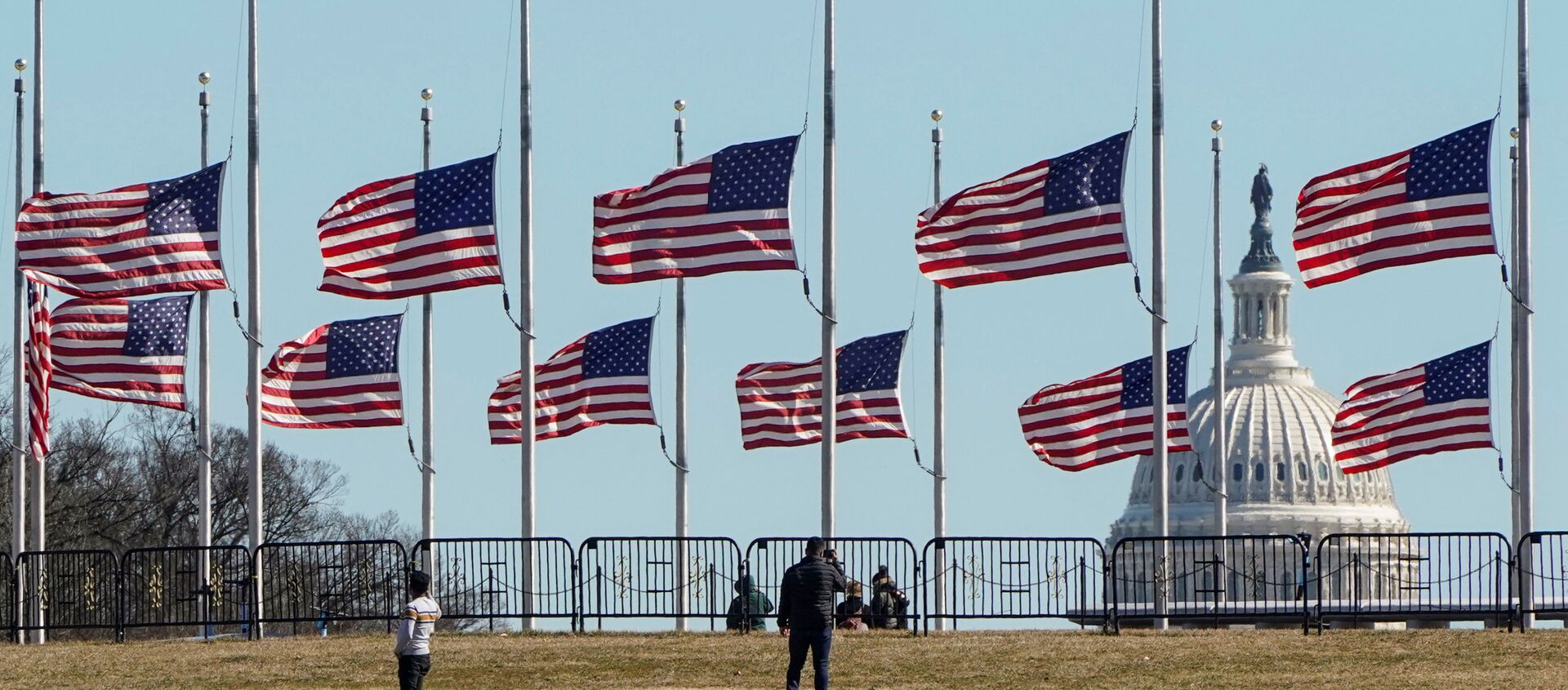 People walk past flags flying at half staff at the Washington Monument in memory of 500,000 deaths due to coronavirus disease (COVID-19) in Washington, U.S., February 24, 2021. - Sputnik International, 1920, 31.03.2021