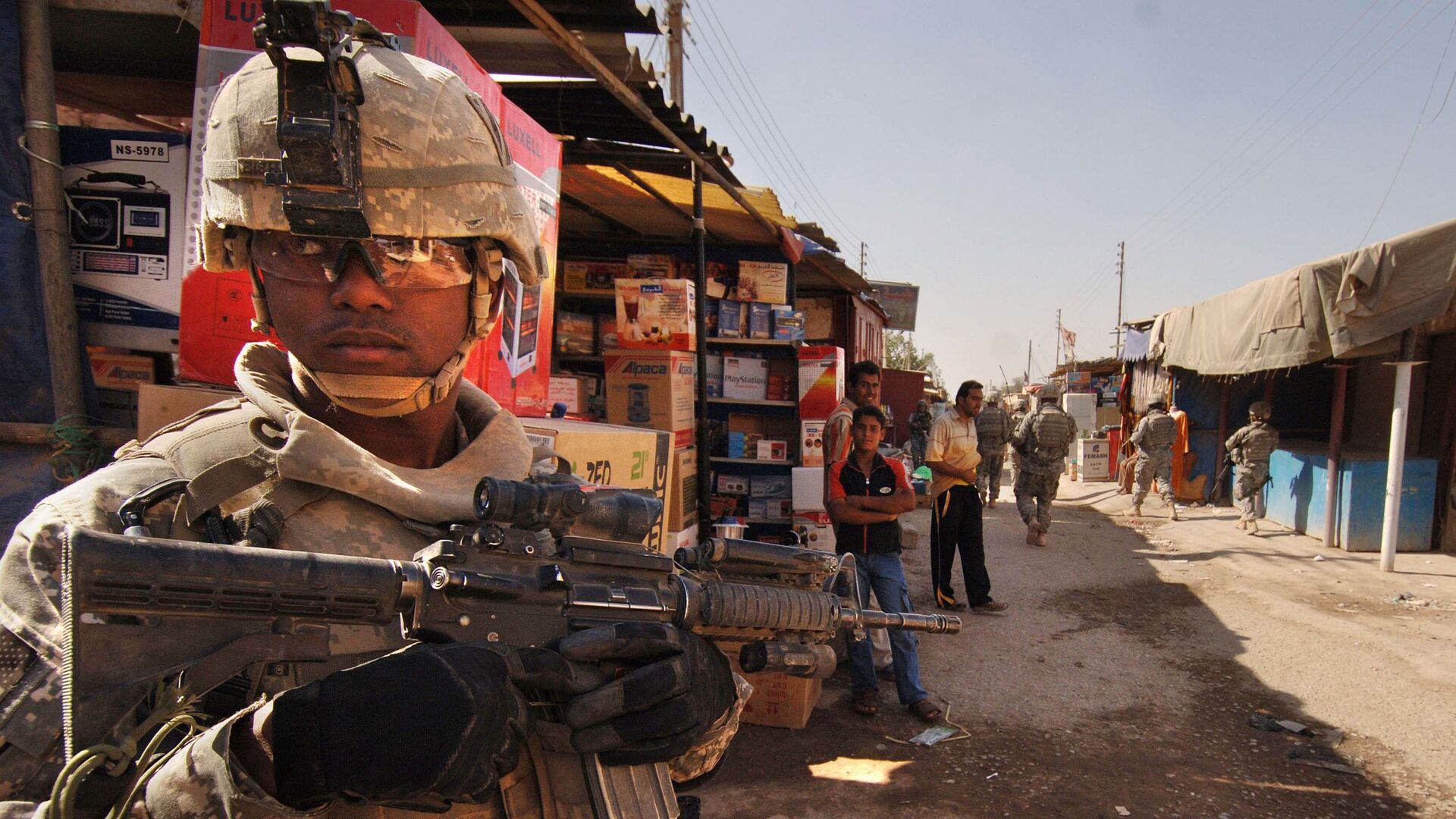U.S. Army Staff Sgt. Jerrime Bishop provides security during a joint dismounted presence patrol with Iraqi National Police at a market in Narhwan, Iraq, Nov. 1, 2007. - Sputnik International, 1920, 31.03.2021
