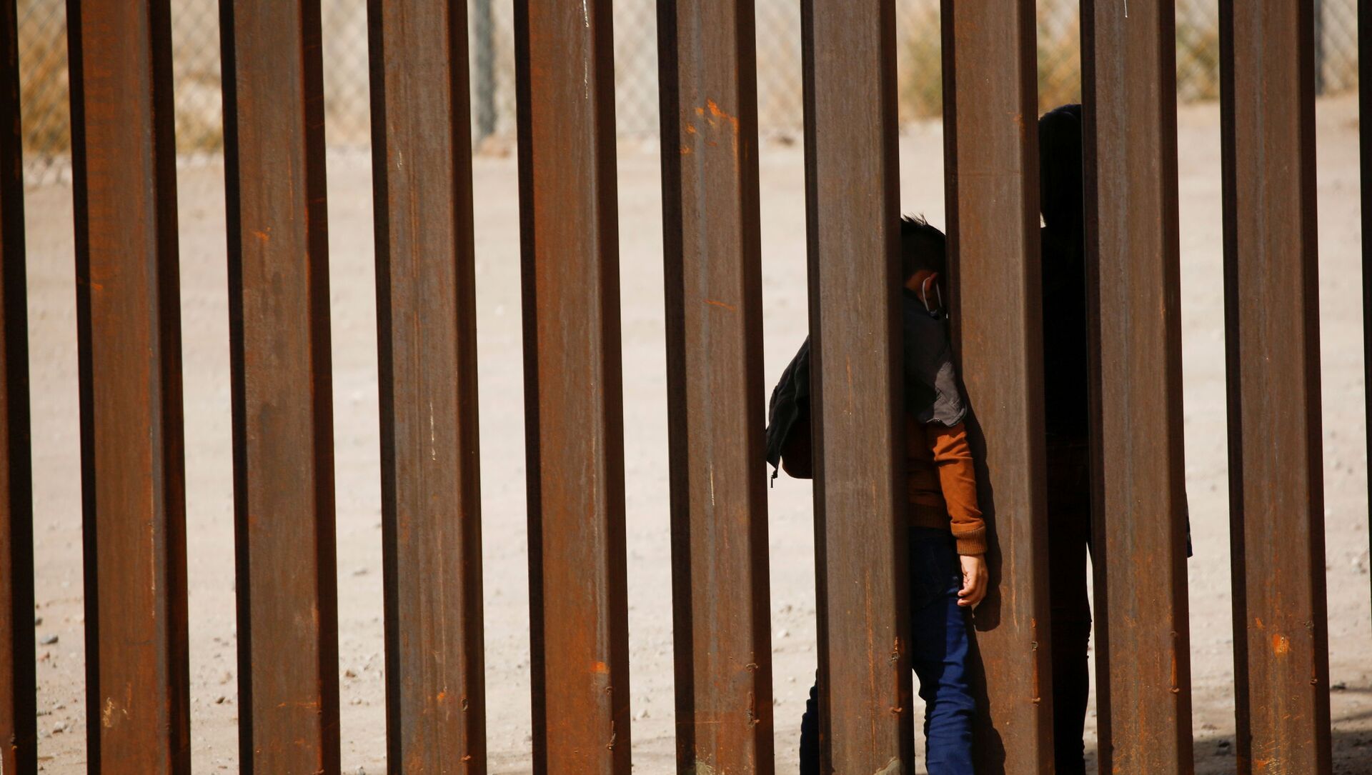 Migrant child is seen through the border wall after crossing the Rio Bravo river to turn himself with his family in to U.S. Border Patrol agents to request for asylum in El Paso, Texas, U.S., as seen from Ciudad Juarez, Mexico March 29, 2021 - Sputnik International, 1920, 01.04.2021
