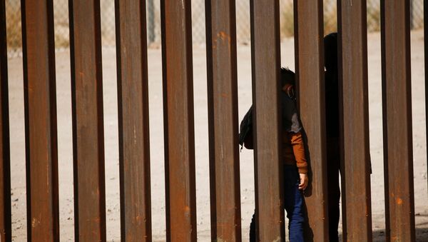 Migrant child is seen through the border wall after crossing the Rio Bravo river to turn himself with his family in to US Border Patrol agents to request for asylum in El Paso, Texas, as seen from Ciudad Juarez, Mexico, 29 March 2021 - Sputnik International