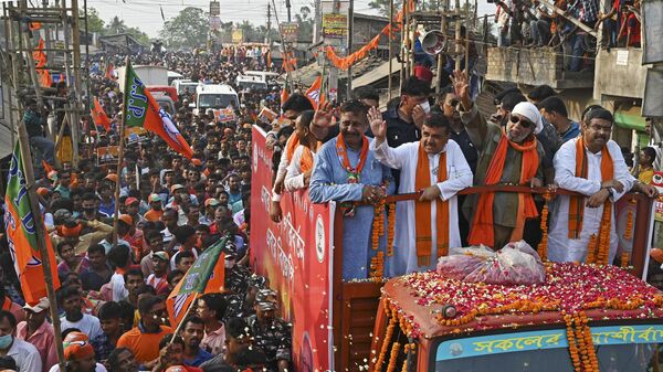 Bollywood actor and Bharatiya Janata Party (BJP)leader Mithun Chakraborty (c, white headgear) with electoral candidate Suvendu Adhikari (c,2L) take part in a road show as a part of election campaign ahead of the 2nd phase of the state Legislative Assembly election in Nandigram around 160 kms west of Kolkata on March 30, 2021 - Sputnik International
