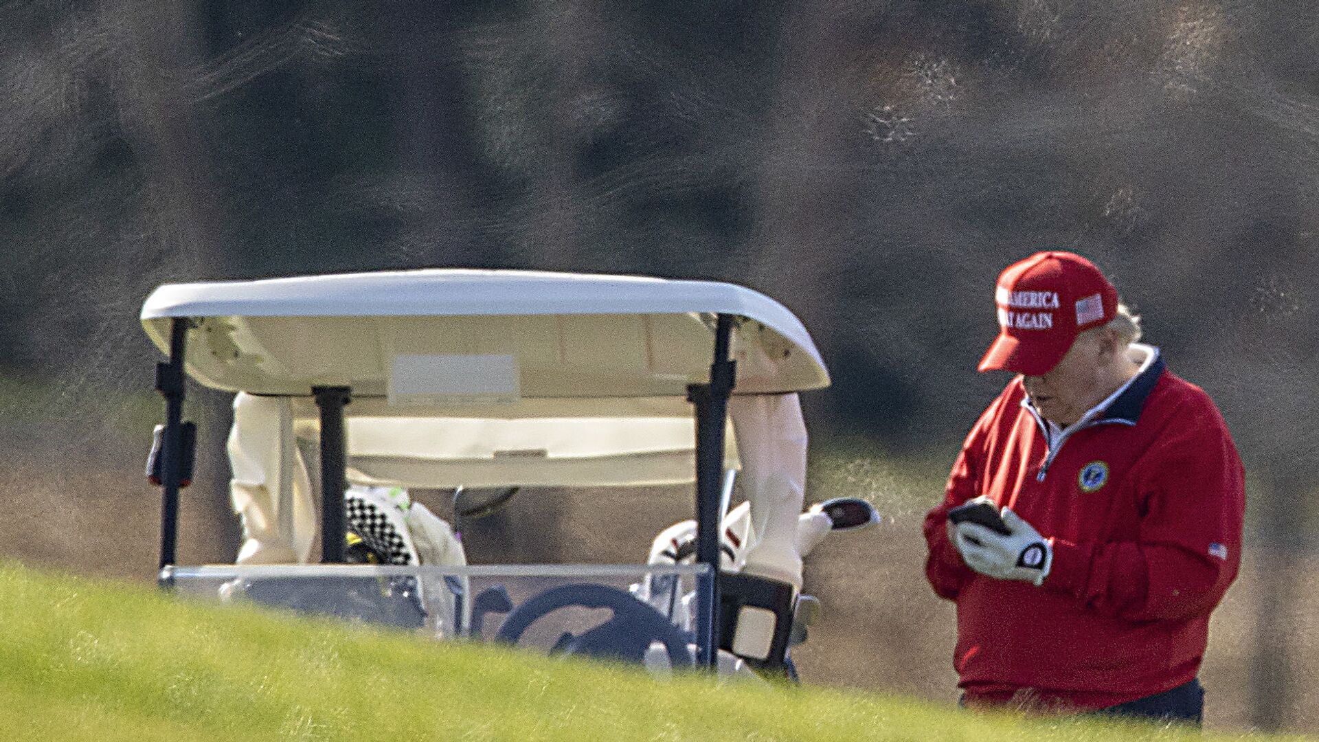  US President Donald Trump makes a phone call as he golfs at Trump National Golf Club on November 26, 2020 in Sterling, Virginia - Sputnik International, 1920, 02.10.2021