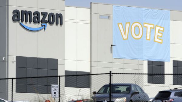 In this Tuesday, March 30, 2021 file photo, A banner encouraging workers to vote in labor balloting is shown at an Amazon warehouse in Bessemer, Ala. - Sputnik International