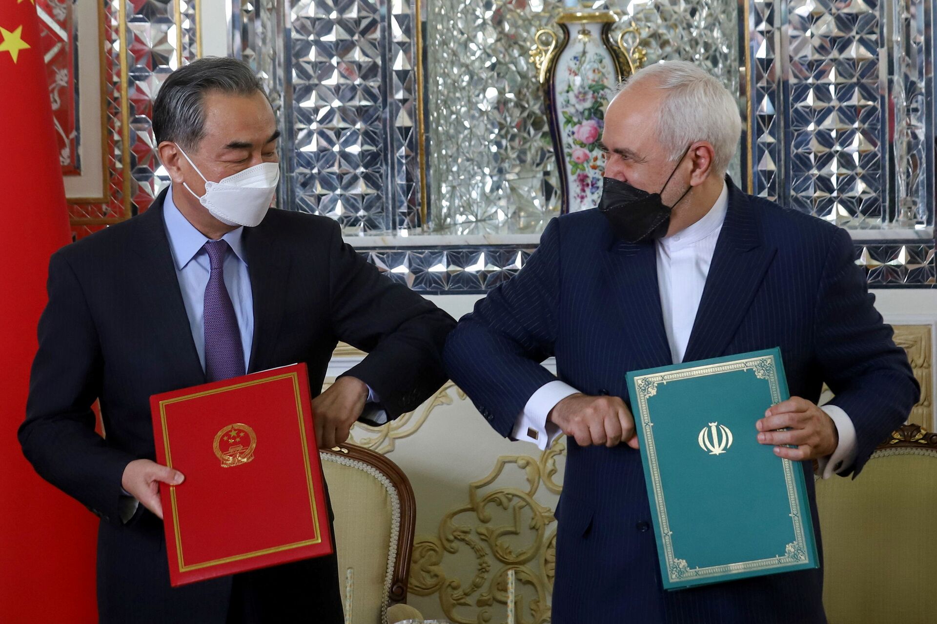 Iran's Foreign Minister Mohammad Javad Zarif and China's Foreign Minister Wang Yi bump elbows during the signing ceremony of a 25-year cooperation agreement, in Tehran, Iran March 27, 2021. - Sputnik International, 1920, 07.09.2021