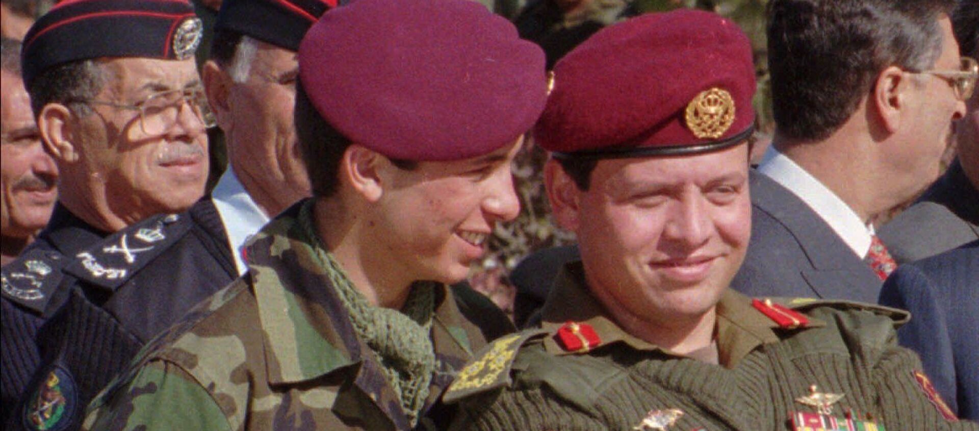Jordan's Prince Hamza, 19, left, whispers in the ears of his elder brother, Prince Abdullah, 37, in this June 1998 photo taken during a military parade in Jordan.  - Sputnik International, 1920, 04.04.2021