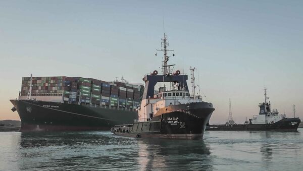 In this photo released by Suez Canal Authority, the Ever Given, a Panama-flagged cargo ship is pulled by one of the Suez Canal tugboats, in the Suez Canal, Egypt, Monday, March 29, 2021 - Sputnik International