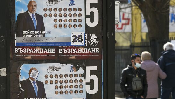 People walk past election posters of Bulgarian Prime Minister and leader of centre-right GERB party Boyko Borissov in Bankya on April 2, 2021, ahead of the General elections in two days. - Bulgarians will go to the polls on April 4, to elect a new parliament, with Prime Minister Boyko Borisov's centre-right party tipped to finish first despite a wave of anti-government protests last summer. While the latest polls give Borisov's GERB party an average lead of eight percentage points over the main opposition Socialists, analysts still expect the next parliament to be marked by more instability. - Sputnik International