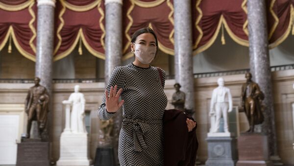 Rep. Alexandria Ocasio-Cortez, D-N.Y., waves to photographers as she walks through Statuary Hall before the vote on the Democrat's $1.9 trillion COVID-19 relief bill, on Capitol Hill, Wednesday, March 10, 2021, in Washington. - Sputnik International
