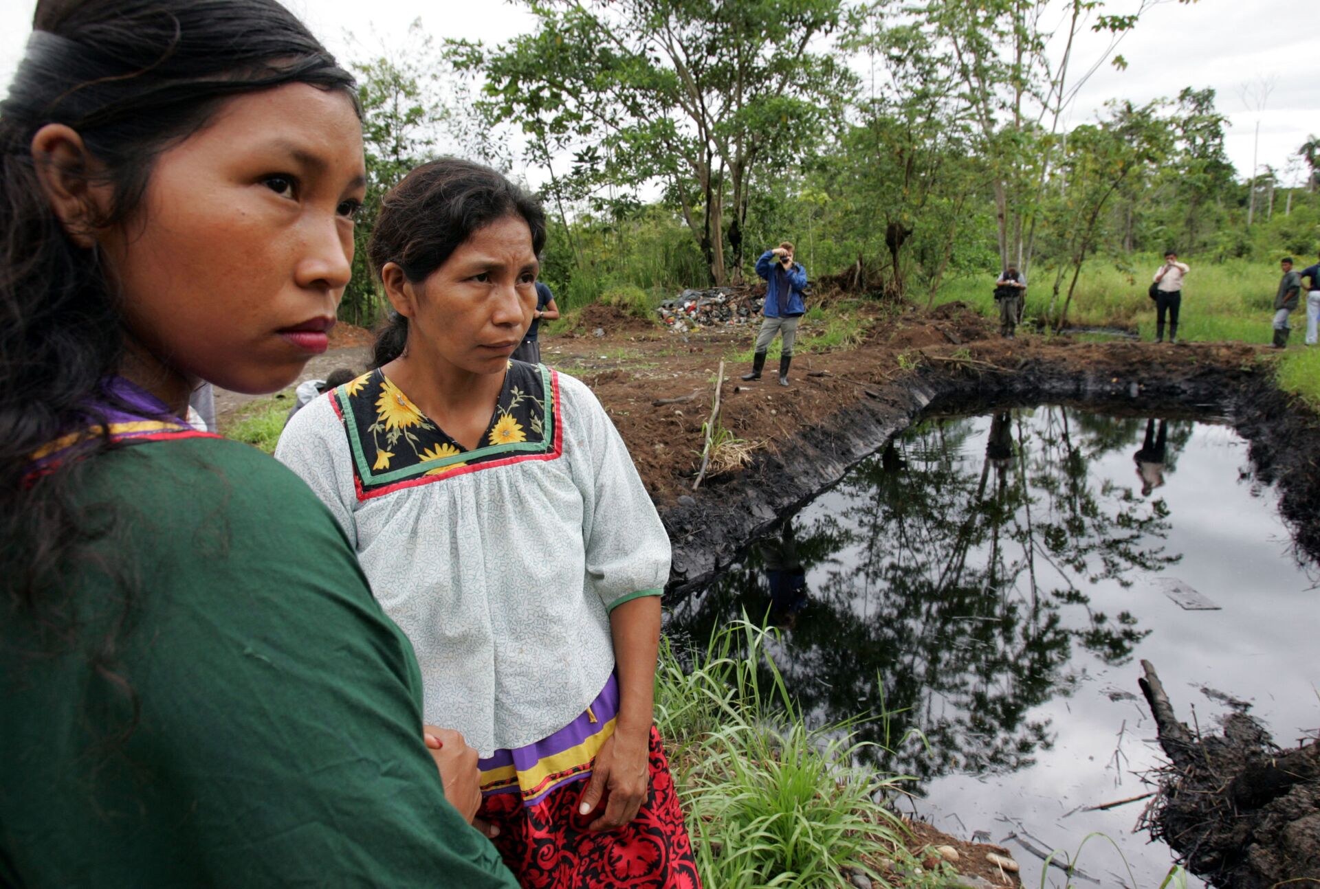 Cofan indigenous women stand near a pool of oil in Ecuador's Amazonian region, Oct. 20, 2005. Ecuador's President Rafael Correa has sided squarely with the 30,000 plaintiffs, Indians and colonists, in a class-action suit, dubbed an Amazon Chernobyl by environmentalists, over the slow poisoning of a Rhode Island-sized expanse of rainforest with millions of gallons of oil and billions more of toxic wastewater. - Sputnik International, 1920, 07.09.2021