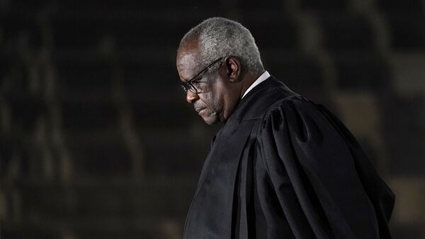 Supreme Court Justice Clarence Thomas listens as President Donald Trump speaks before administering the Constitutional Oath to Amy Coney Barrett on the South Lawn of the White House in Washington, Monday, Oct. 26, 2020, after she was confirmed by the Senate earlier in the evening. - Sputnik International
