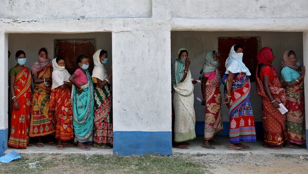 Women wait in line to cast their vote at a polling booth during the first phase of West Bengal state election in the Purulia district, India. - Sputnik International