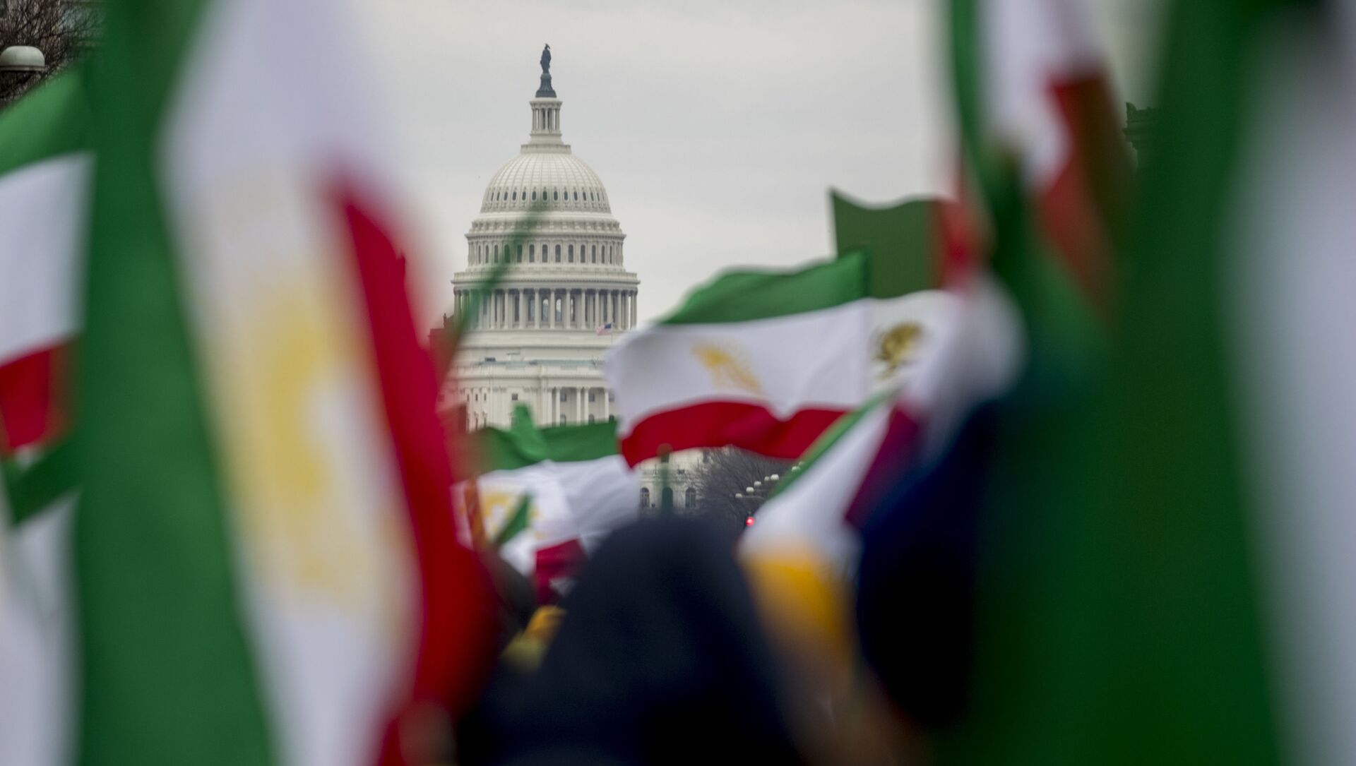 The Dome of the U.S. Capitol building is visible through Iranian flags during an Organization of Iranian-American Communities rally at Freedom Plaza in Washington, Friday, March 8, 2019.  - Sputnik International, 1920, 12.07.2021
