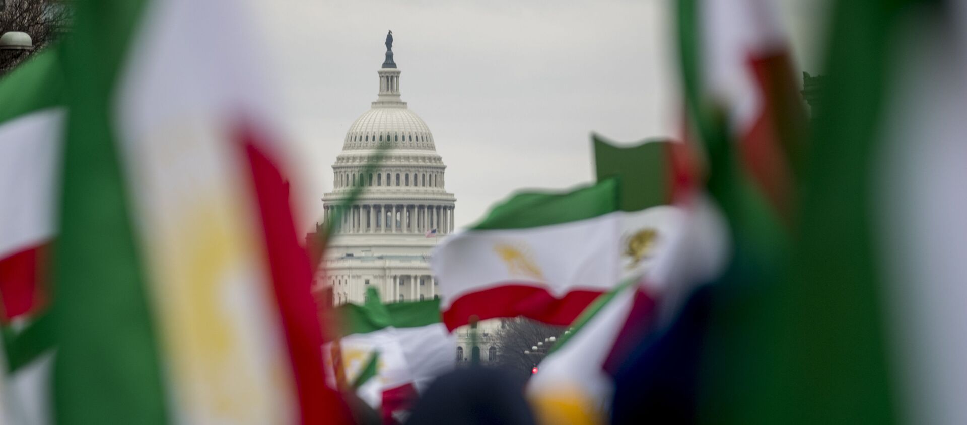 The Dome of the U.S. Capitol building is visible through Iranian flags during an Organization of Iranian-American Communities rally at Freedom Plaza in Washington, Friday, March 8, 2019.  - Sputnik International, 1920, 06.04.2021
