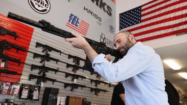 Austin Title handles a weapon as he visits WEX Gunworks on March 24, 2021 in Delray Beach, Florida. U.S. President Joe Biden has called on lawmakers to “immediately pass” legislation to help curb gun violence in the county.   - Sputnik International
