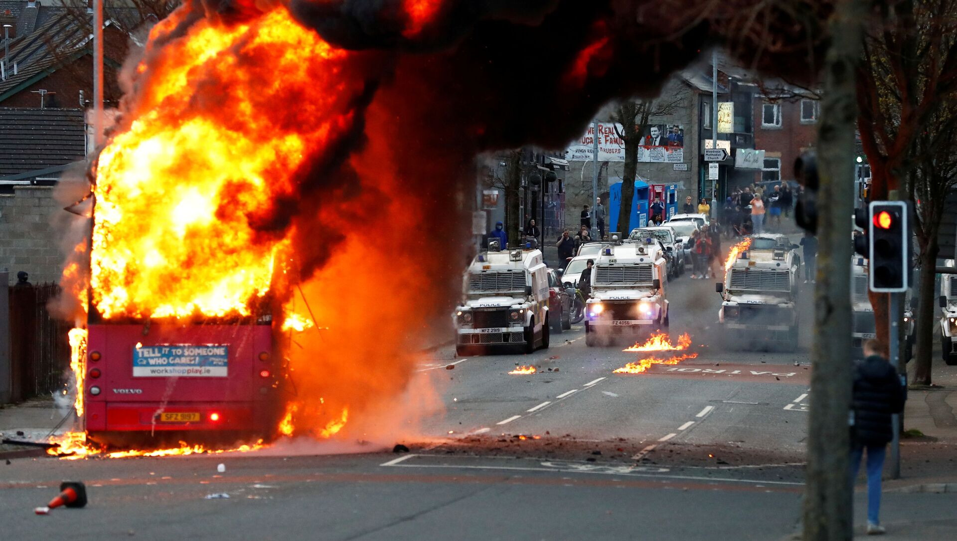 Police vehicles are seen behind a hijacked bus burns on the Shankill Road as protests continue in Belfast, Northern Ireland, April 7, 2021 - Sputnik International, 1920, 08.04.2021
