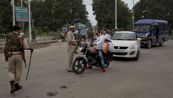 An Indian police man interrogates a Kashmiri couple before turning them back at a checkpoint during security lockdown in Srinagar, Indian controlled Kashmir, Thursday, Aug. 15, 2019 - Sputnik International