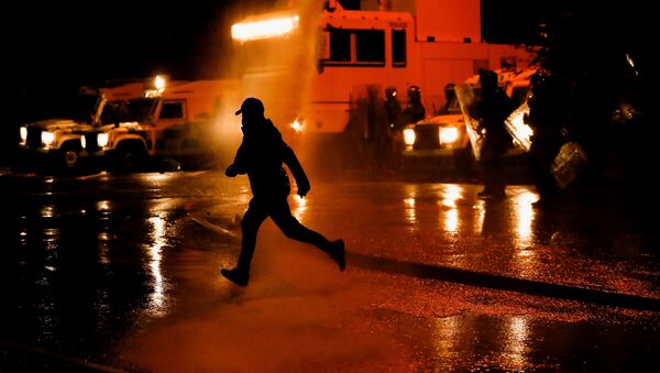 A rioter reacts as the police use a water cannon on Springfield Road as protests continue in Belfast, Northern Ireland April 8, 2021. - Sputnik International