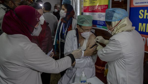 A Kashmiri doctor receives a COVID-19 vaccine at a government Hospital in Srinagar, Indian controlled Kashmir, Saturday, 16 January 2021 - Sputnik International