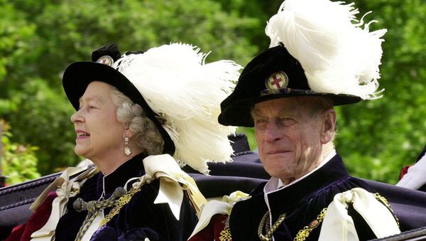 FILE PHOTO: Britain's Queen Elizabeth II and Prince Phillip, the Duke of Edinburgh, wearing their Order of the Garter robes, ride in an open-topped carriage to Windsor Castle - Sputnik International