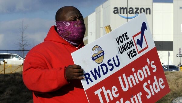 FILE - In this Tuesday, Feb. 9, 2021, file photo, Michael Foster of the Retail, Wholesale and Department Store Union holds a sign outside an Amazon facility where labor is trying to organize workers in Bessemer, Ala. - Sputnik International
