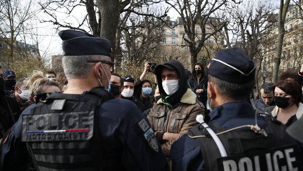 A man faces police officers during a counter-protest while supporters of the group Generation Identity demonstrate, Saturday, Feb. 20, 2021 in Paris. Supporters of Europe's extreme-right, anti-migrant movement Generation Identity protest against French government efforts to shut it down as a racist militia. - Sputnik International