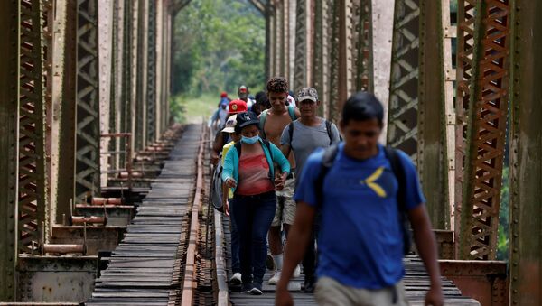 A group of migrants from Honduras walk along the railway track on their way to the United States in Huimanguillo, Tabasco, Mexico March 30, 2021 - Sputnik International